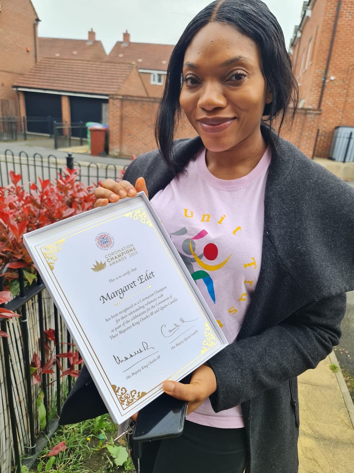 Margaret holding her King's Coronation Champions certificate