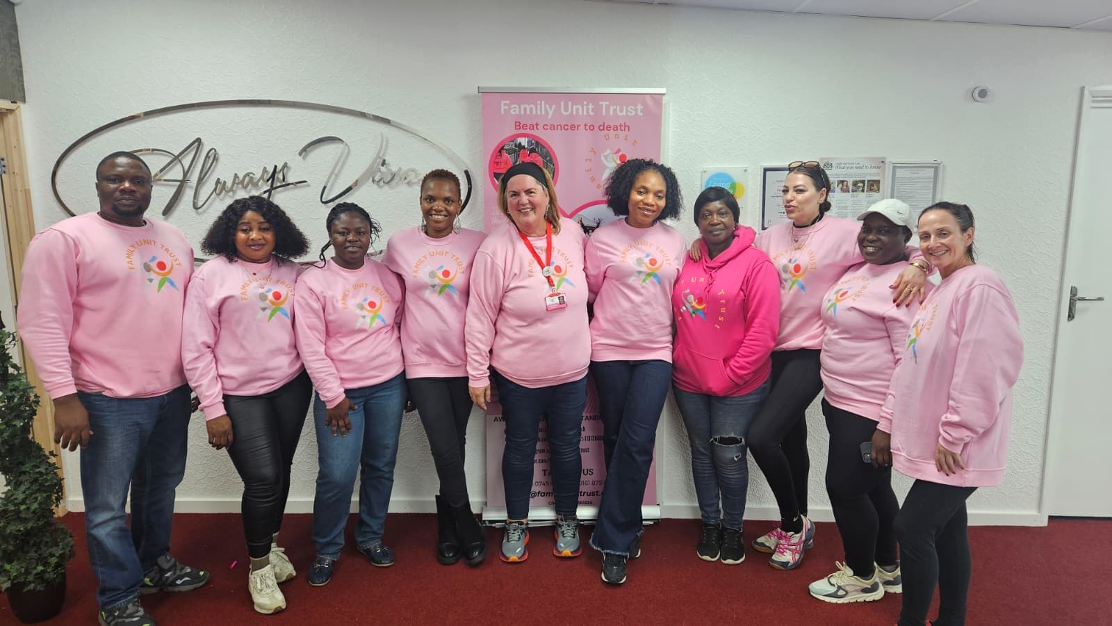 The Family Unit Trust volunteer team in branded pink sweatshirts at our Manchester centre
