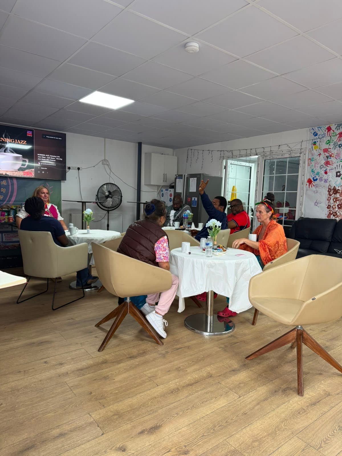 Community members chatting over tea at Coffee Morning.